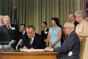 Lyndon B. Johnson signs legislation amending the Social Security Act.